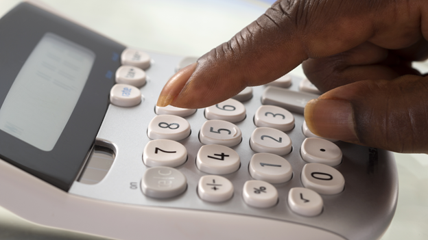 fingers typing on a calculator