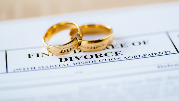 wedding rings resting on top of divorce paperwork