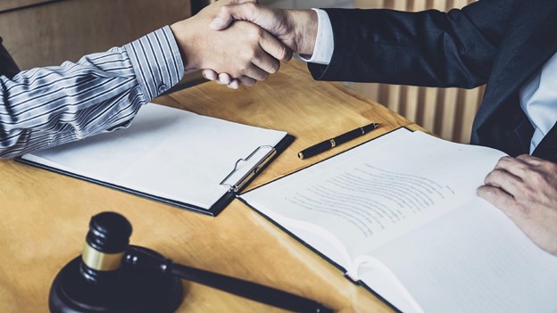 a client shakes hands with an attorney