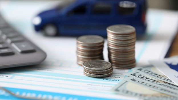 coins sit in front of a toy car and a calculator