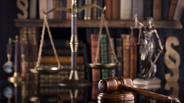 a gavel sits in front of justice scales