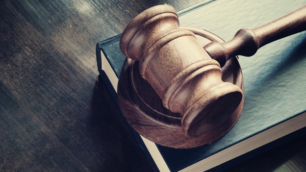 a gavel sits on top of a law book