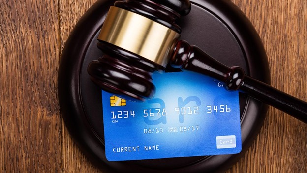 a gavel sits on top of a credit card