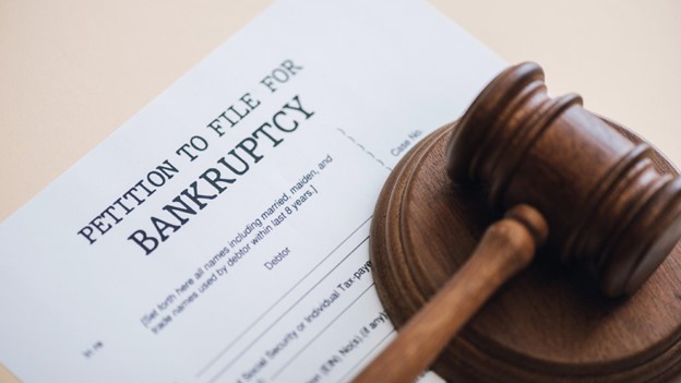 a gavel sits on top of a petition to file for bankruptcy