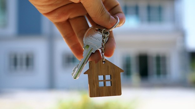 a hand holds keys to a home