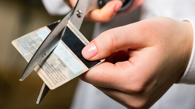 a person cuts up a credit card with scissors