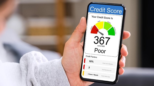 a person holds a mobile phone with a poor credit score on display