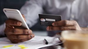 a person makes a credit card payment on a mobile phone