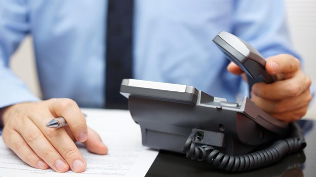 a person picks up a phone to contact a Texas foreclosure lawyer today