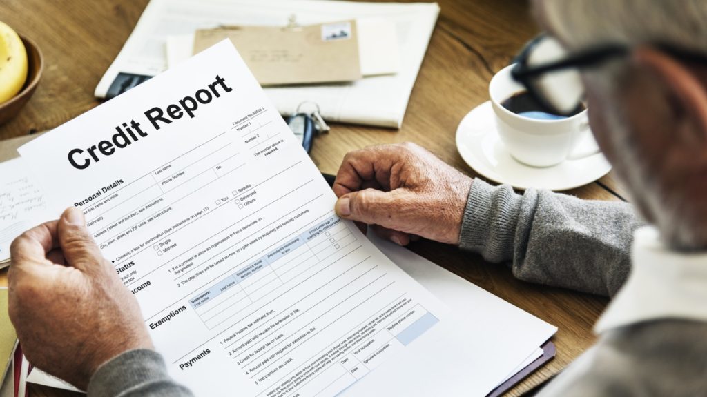 a person reviews their credit report as they wonder, “How will filing Chapter 7 impact my credit?"