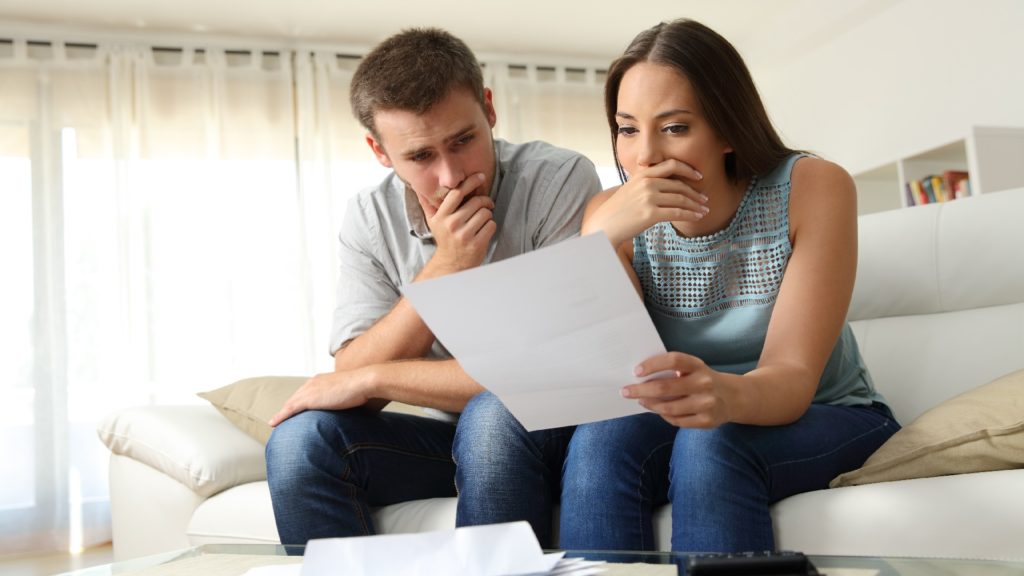 a distraught couple reviews paperwork
