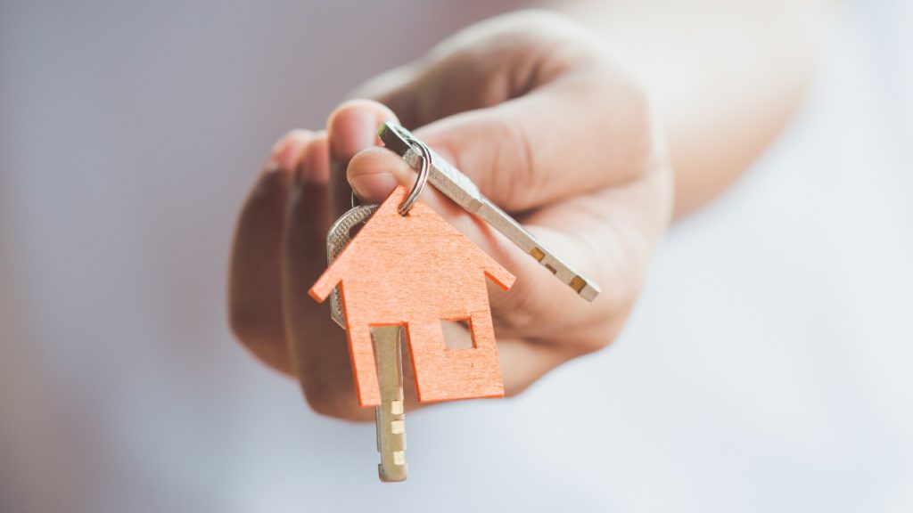 a hand is holding a house key