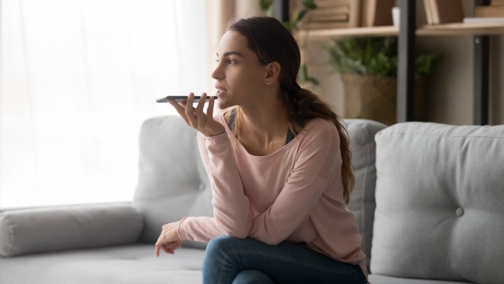 a person talks on a smartphone while sitting on a couch