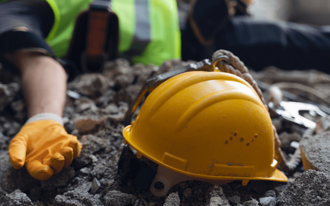 construction accident with construction worker lying down in rubble next to hard hat