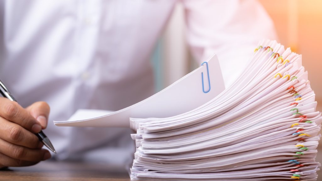 a person looks through a pile of business documents