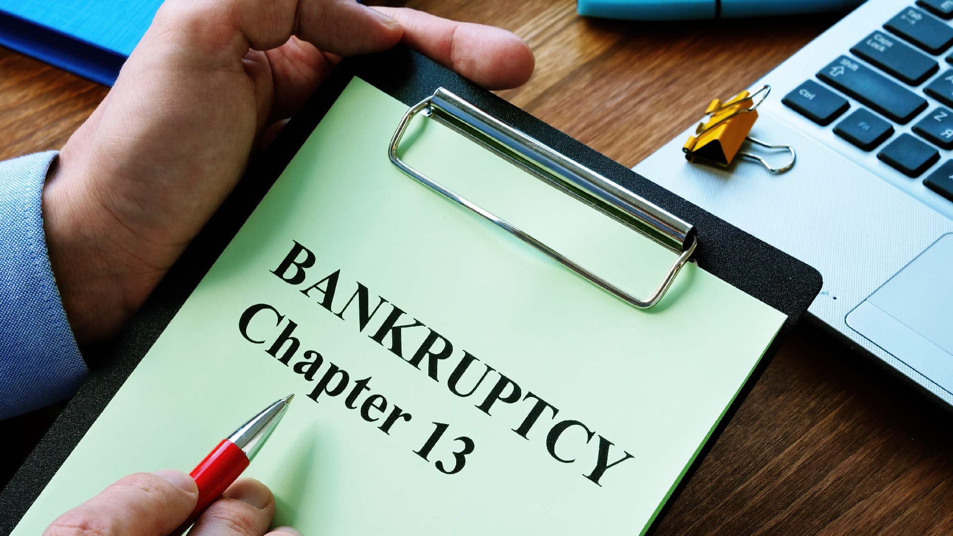 A paper on a clipboard is labeled “Bankruptcy Chapter 13