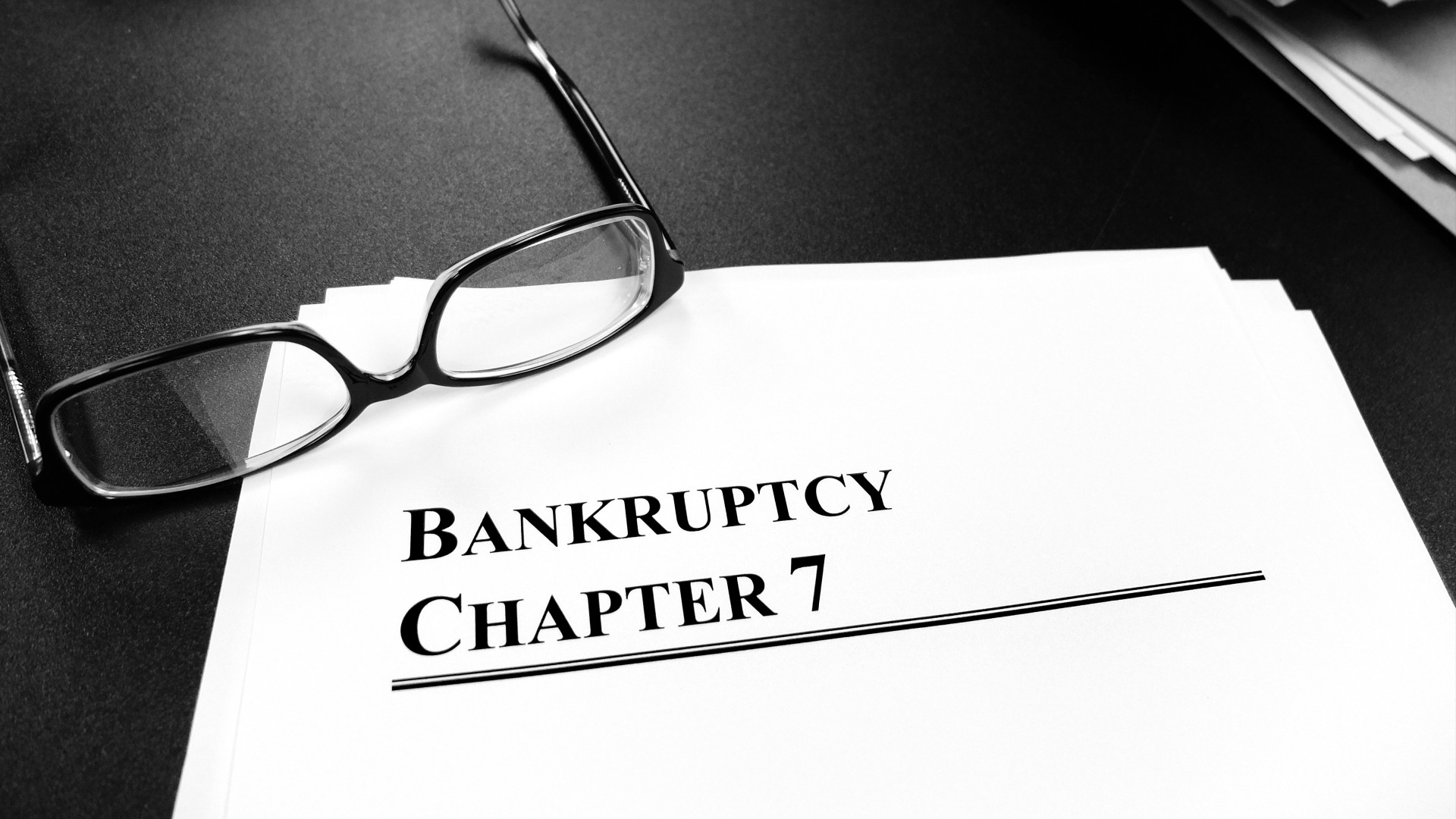Bankruptcy Chapter 7 documents with glasses on top