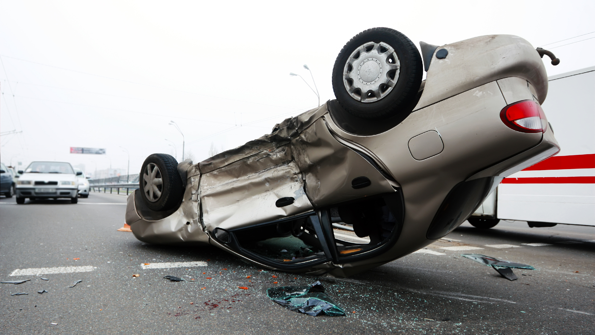 A totaled car flipped over after a car accident in a parking lot