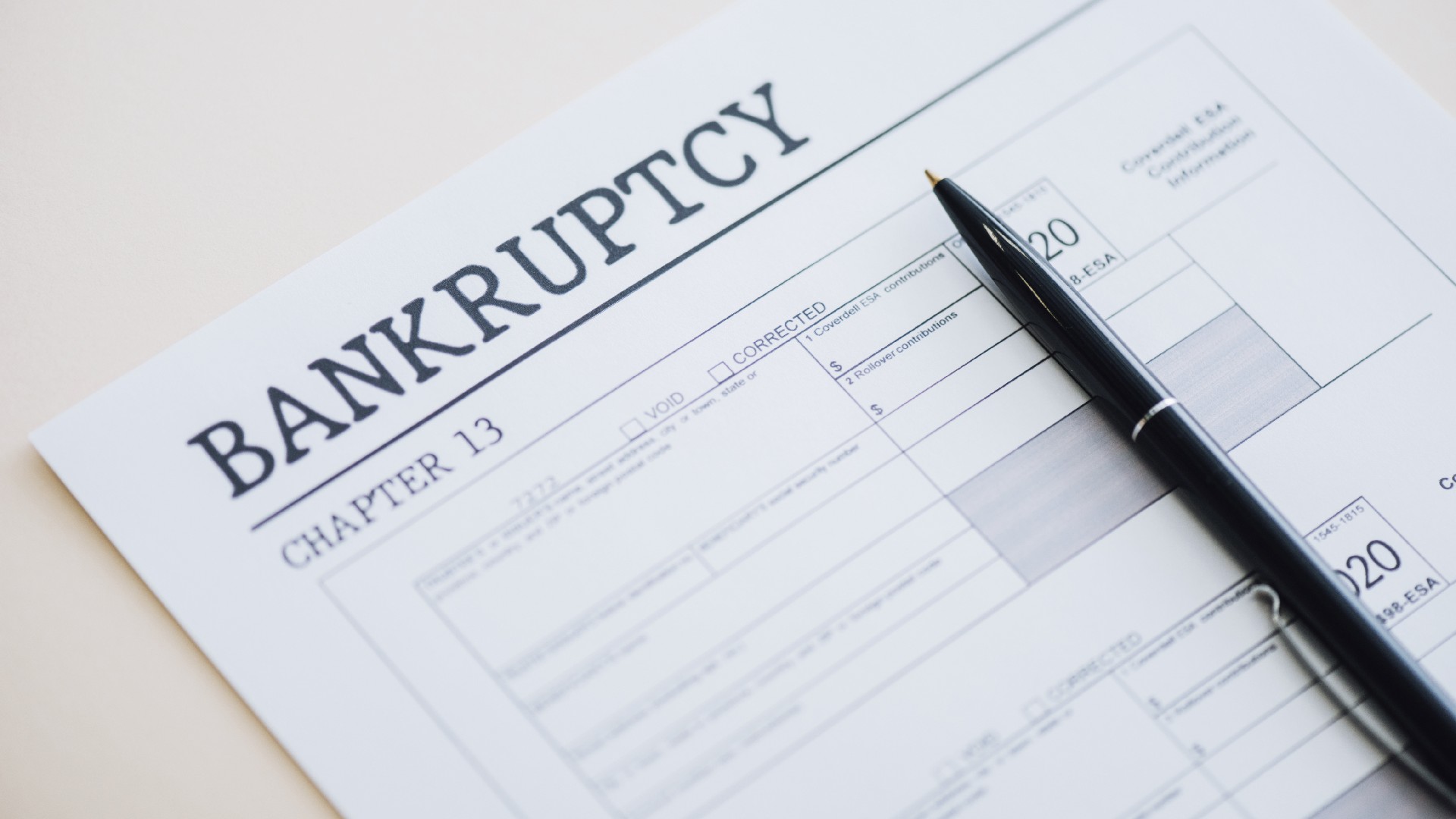 A pen sits on top of Chapter 13 bankruptcy paperwork