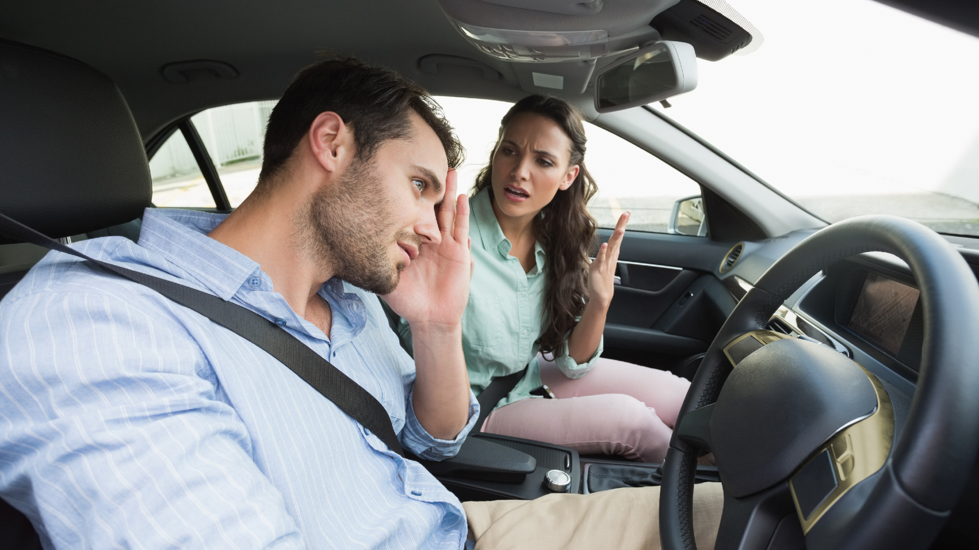 A man drives while his significant other yells at him from the passenger seat