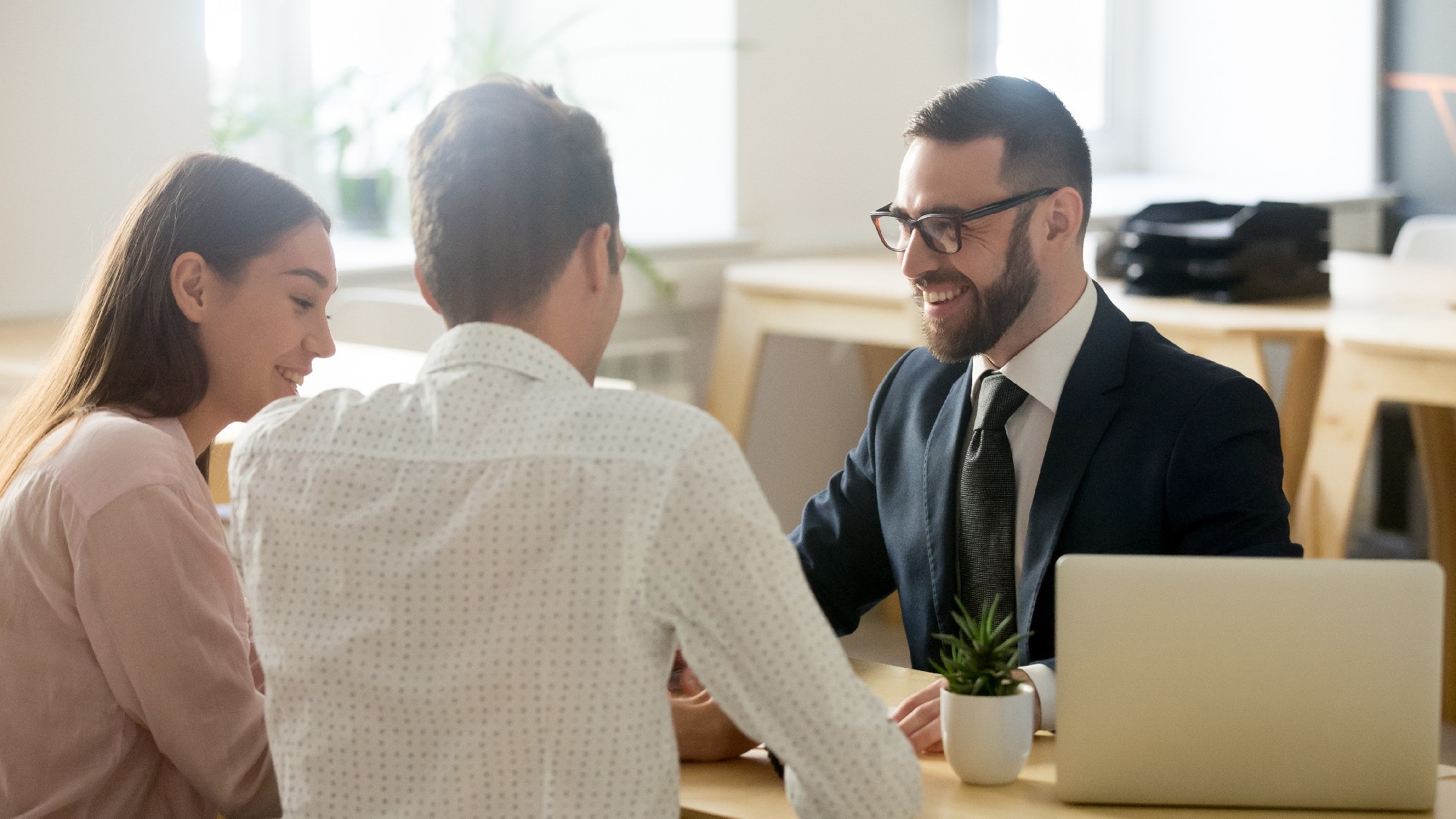 A couple speaks to a happy lawyer at their desk