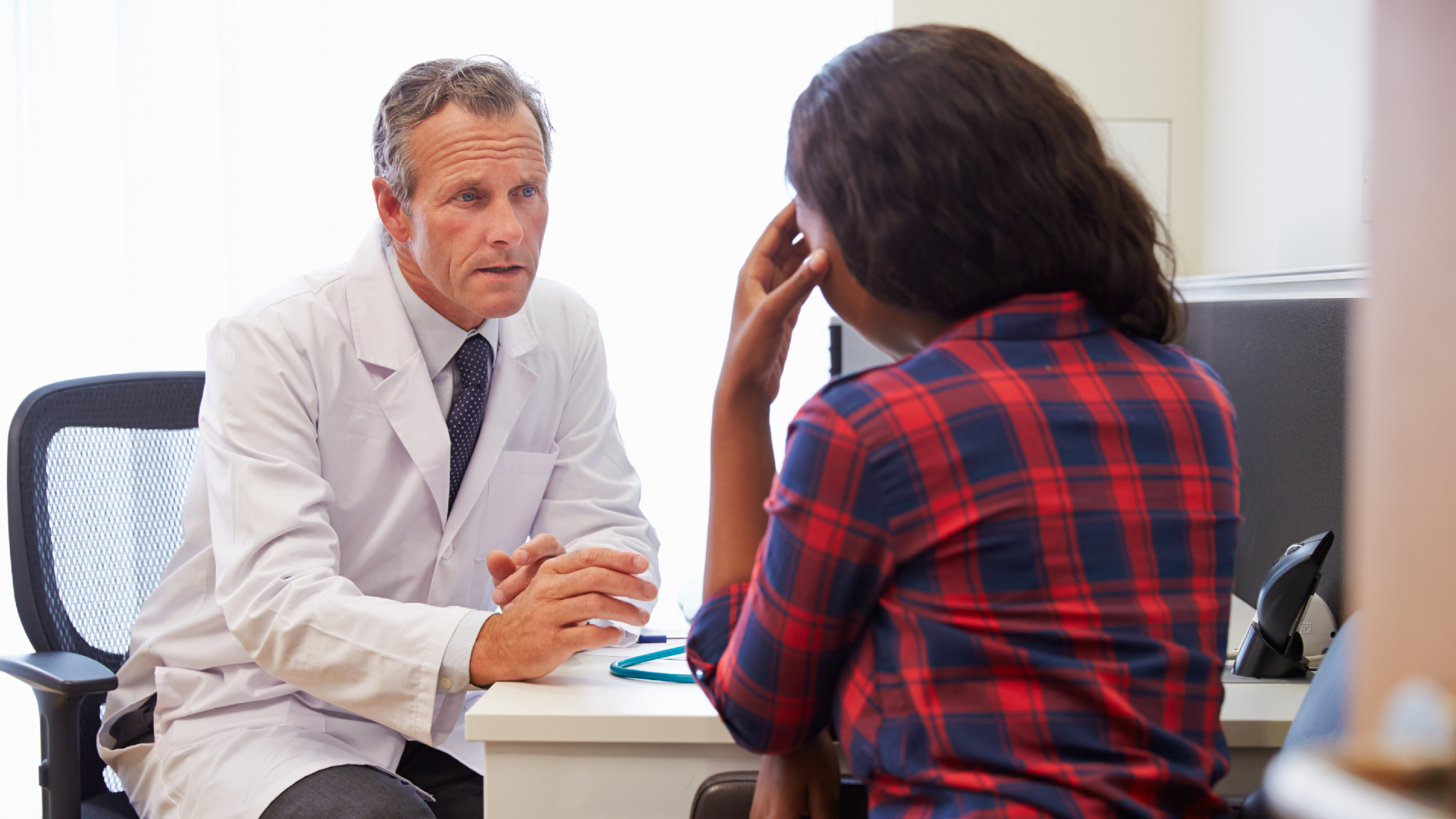 A doctor speaking to their patient at desk