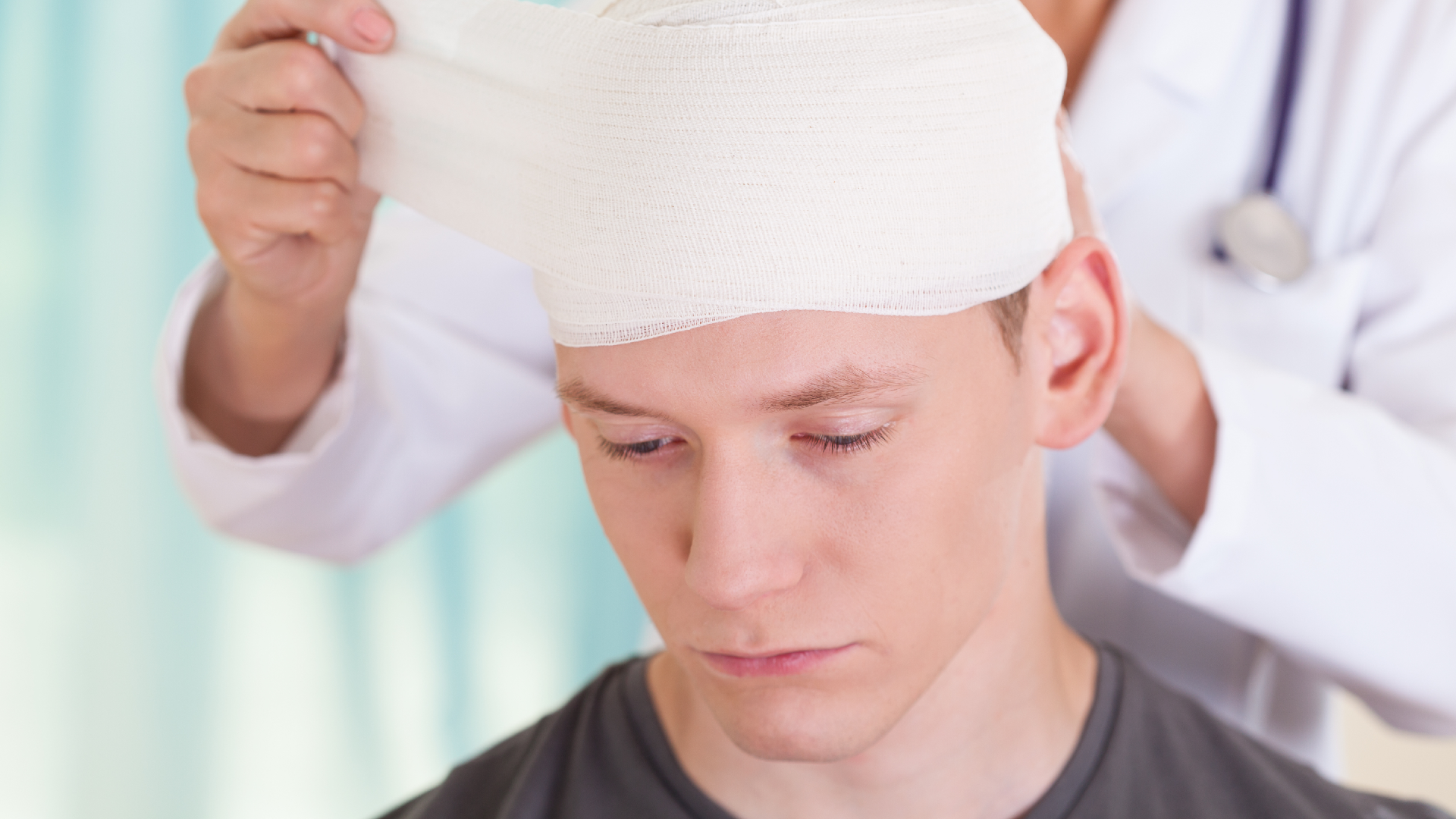 A doctor wrapping a patient’s head with a bandage