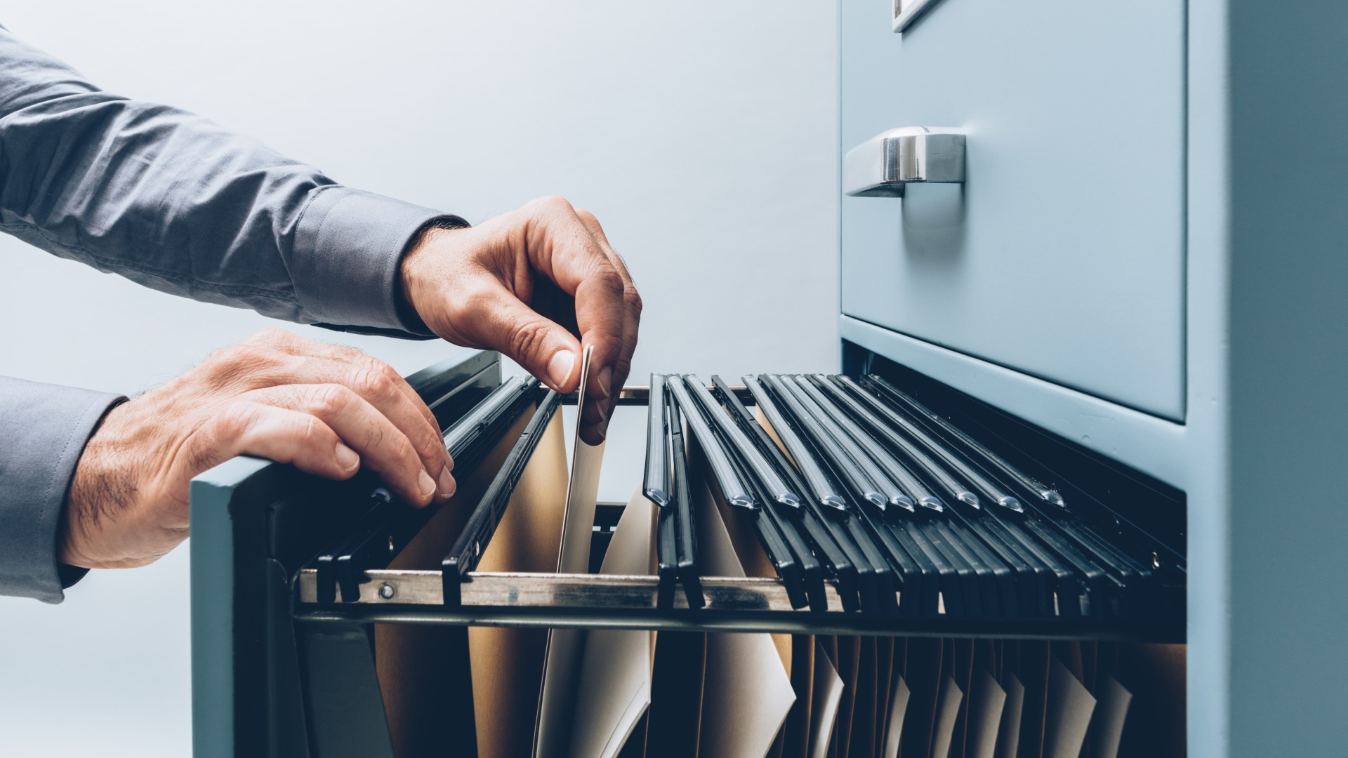 A person opens a filing cabinet