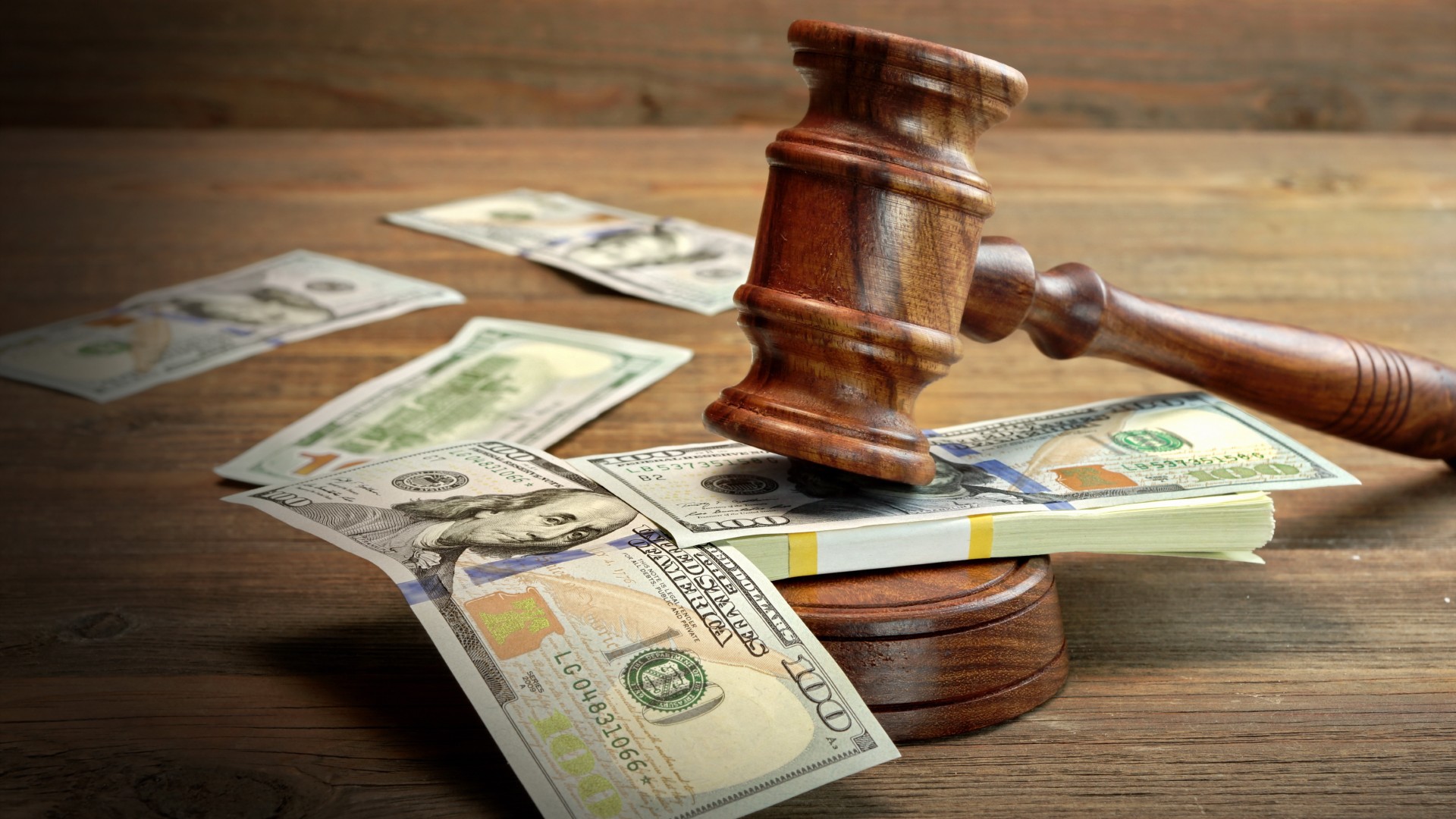 A gavel hits a pile of money