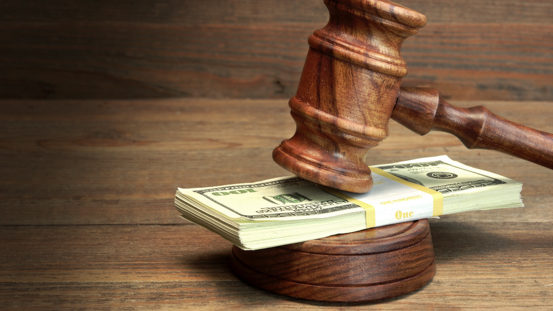 A gavel hitting a pile of money