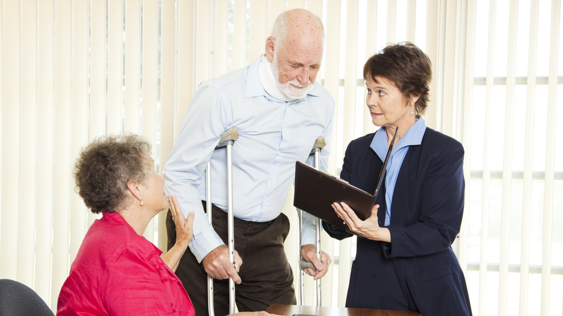 A man walks on crutches and wears a neck brace as his wife guides him and he speaks to personal injury lawyer