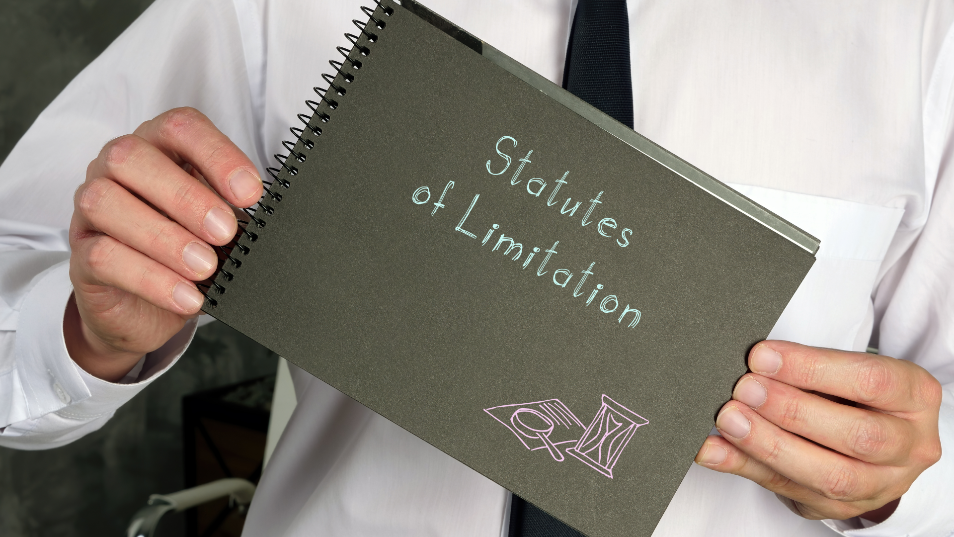 A man holding a book on statutes of limitations