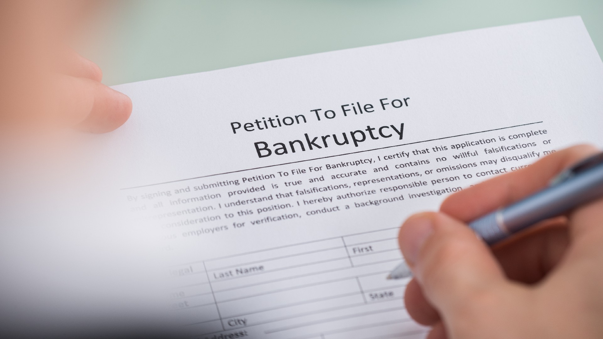 A person fills out a petition to file for bankruptcy