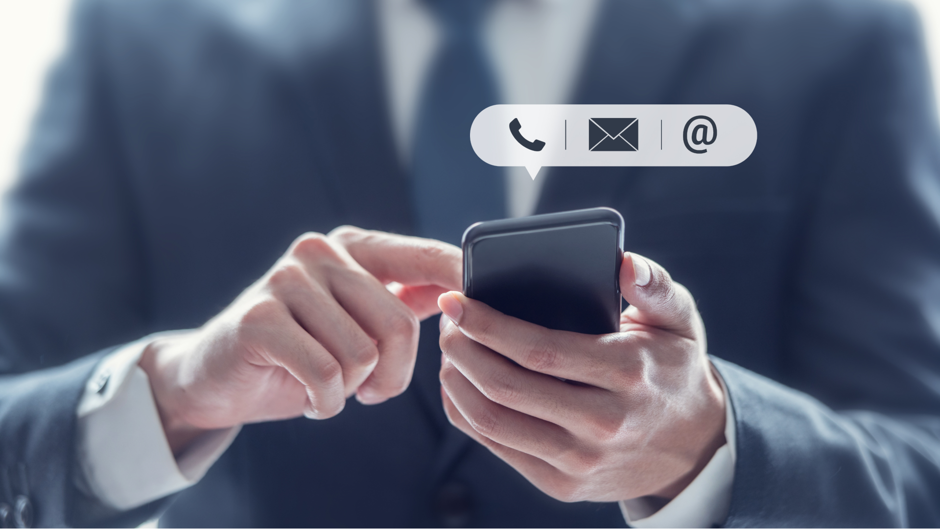 A person typing on a smartphone which shows icons for email phone and social media