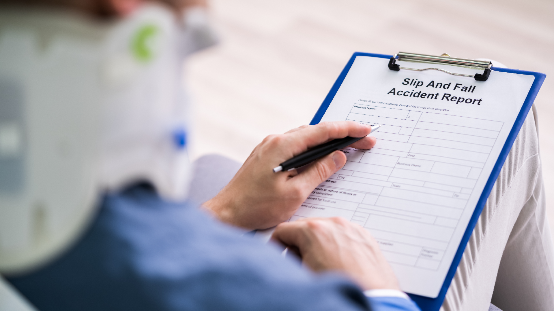 A person wearing a neck brace while looking over a slip-and-fall accident report