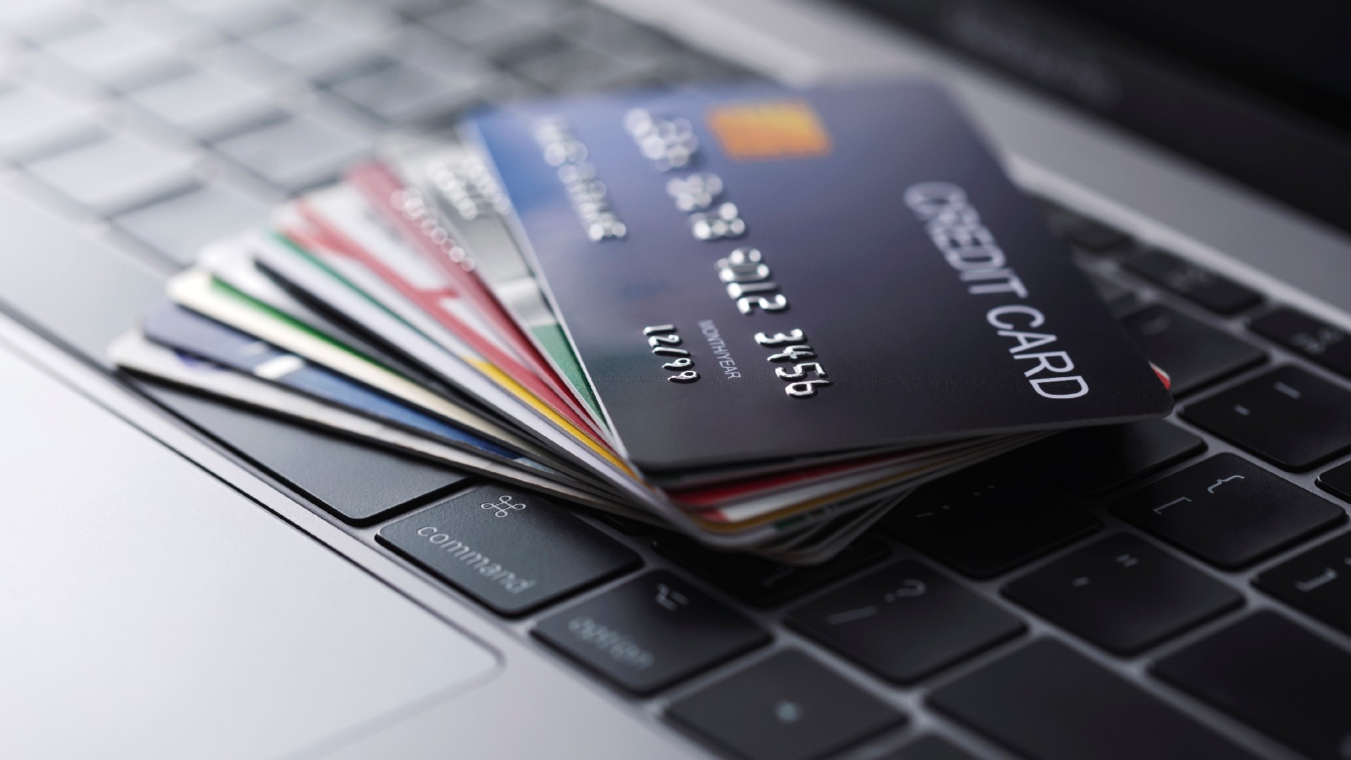 A pile of credit cards sit on a keyboard