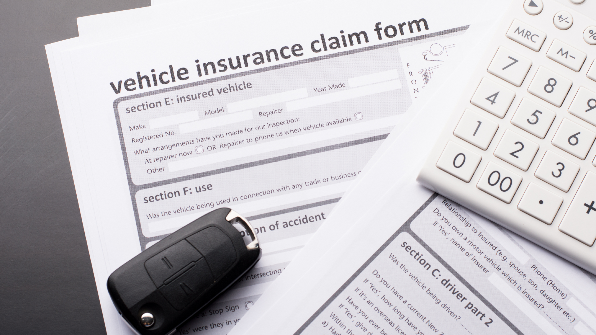 A vehicle insurance claim form with car keys on top