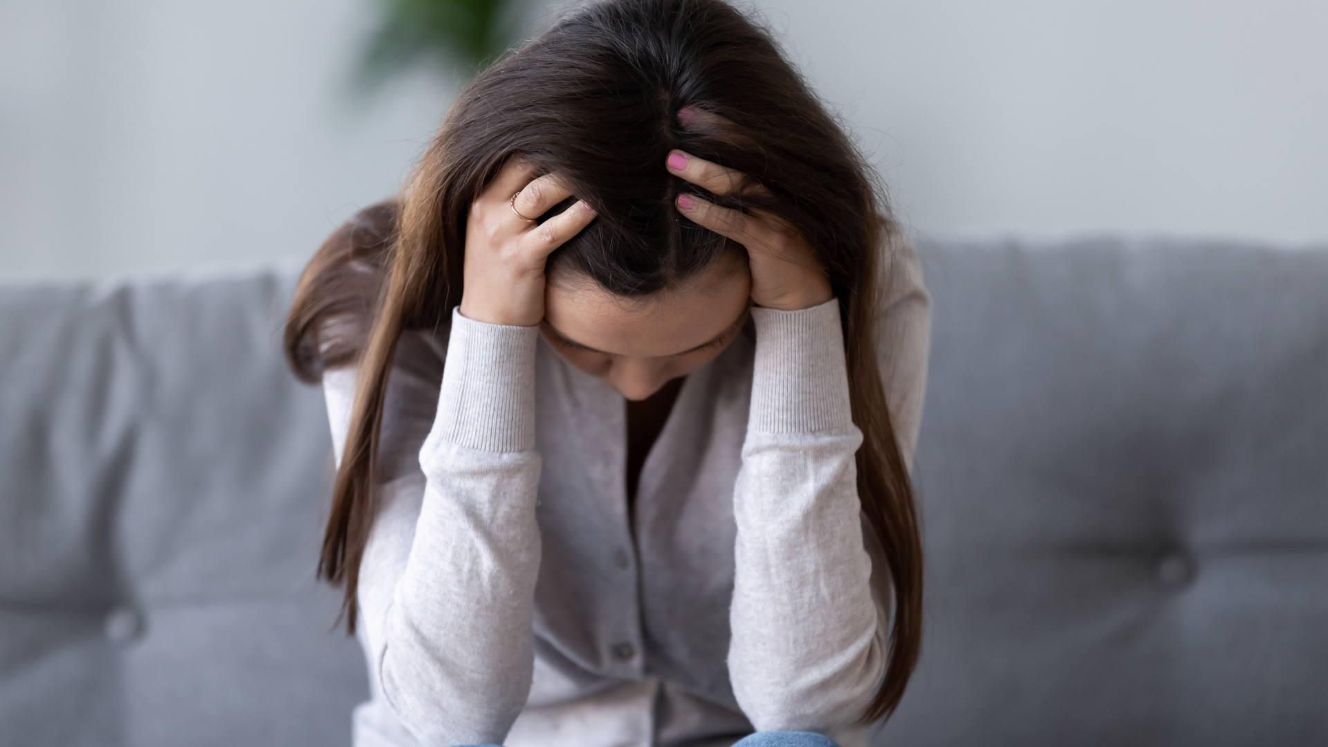 A woman putting her head in her hands in despair