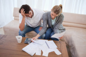Stressed man and woman looking over financial pages