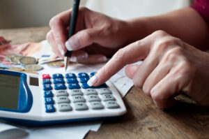 bankruptcy attorney with a closeup of woman with calculator and money on desk